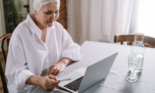 Starsza Pani pracuje przy laptopie